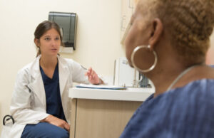 Preguntas y respuestas sobre la viruela M Doctora explicando los síntomas de la viruela M a una paciente