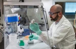 Un estudio confirma en gran medida los efectos secundarios ya conocidos y poco comunes de la vacuna contra el COVID-19 Científico estudiando los efectos poco comunes de las vacunas contra el COVID-19