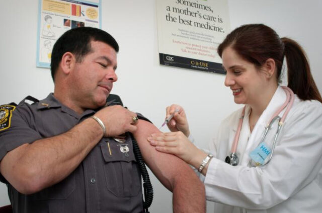 Doctora inyectando a un paciente después de resolver su duda de si la vacuna contra el Covid afecta el corazón.