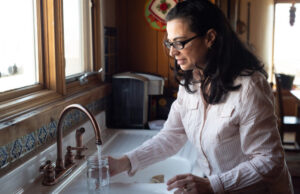 Los CDC y los expertos afirman que el agua fluorada es segura, al contrario de las advertencias de RFK Jr. Mujer sacando agua de su grifo luego de que las autoridades señalaran que el agua fluorada es segura.