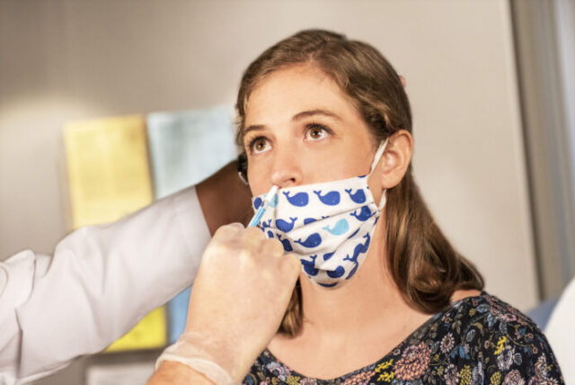 Mujer usando un cubrebocas después de consultar la revisión Cochrane sobre las mascarillas