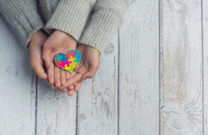 Publicaciones virales hacen mal uso de un estudio en ratas para hacer afirmaciones infundadas sobre las vacunas contra el COVID-19 y el autismo Vacuna covid y autismo: adulto y niño sosteniendo un corazón con los característicos colores del autismo.