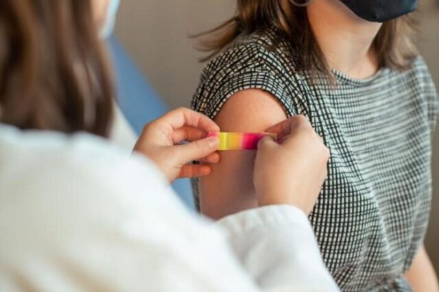 Mujer joven recibiendo una dosis de vacuna con virus vivos