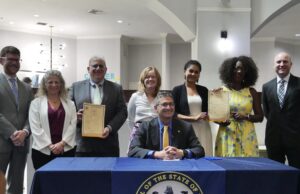 Gov. Meyer announces partnership for $50 million in medical debt elimination Gov. Meyer signing partnership for $50 million in medical debt elimination. (Photo courtesy Gov. Meyer Office).