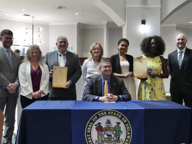 Gov. Meyer signing partnership for $50 million in medical debt elimination. (Photo courtesy Gov. Meyer Office).