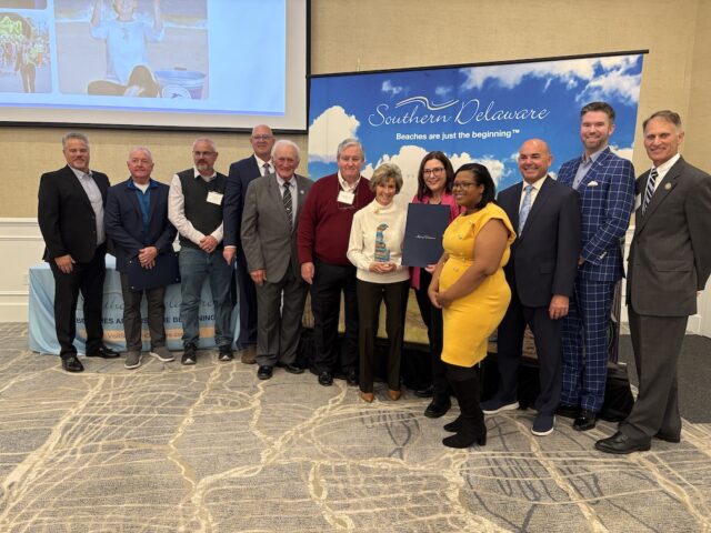 Legacy Award: Winner Carol Everhart. L to R: Scott Anthony, Southern Delaware Tourism Chairperson; Doug Hudson, Sussex County Council President; Steve McCarron, Sussex County Councilman; Russ Huxtable, DE State Senator; Dave Wilson, DE State Senator; John Rieley, Sussex County Council Vice President; Carol Everhart, honoree; Claire Snyder-Hall, DE State Representative; Alonna Berry, DE State Representative; Scott Thomas, Executive Director of Southern Delaware Tourism; Benjamin Gray, COO Mercantile Processing; Ron Gray, DE State Representative (Photo courtesy Southern Tourism)