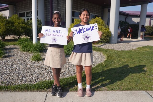 Sussex Academy Elementary students Bethsaida Bellevue, left, and Sayuri Perez Perez welcome guests to the school’s second annual open house for elected leaders and community representatives.
